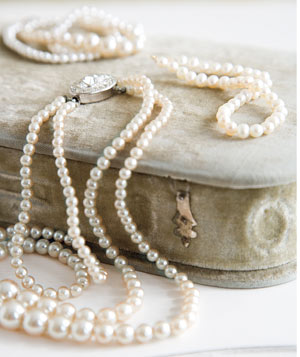 Pearls, Female hand holding string of fake pearls., style code